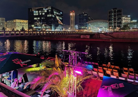 Nightlife on Ludwig-Erhard-Ufer in an outdoor restaurant with the Spree and Berlin Central Station