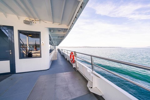Side of a ship with lifebuoy, looking out over the sea on a clear blue day, boat trip, Lake