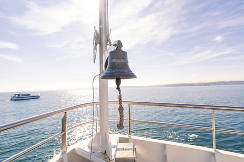 Ship bell aboard a boat on a calm sea under sunny sky, boat trip, Lake Constance, Germany