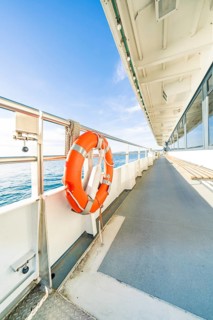 Side view from a ship deck with lifebuoy, calm sea and sunny sky, boat trip, Lake Constance,