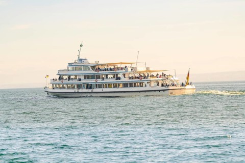 Large passenger ship full of people on calm water under a sunny sky, boat trip, Lake Constance,