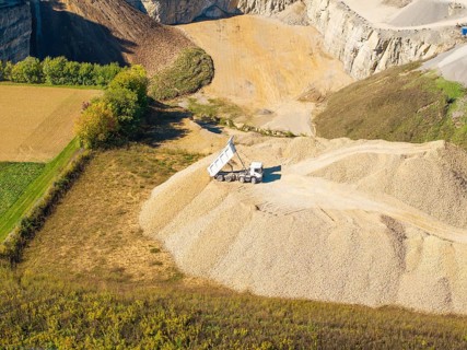 A dump truck seen from the air on a pile of sand near a quarry, Nagold, Black Forest, Germany