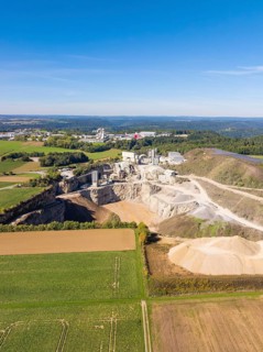 A spacious aerial view of a quarry surrounded by fields and forests, Nagold, Black Forest, Germany