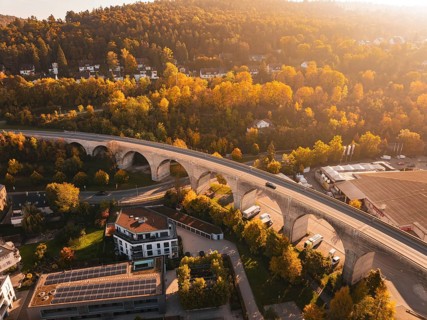 A viaduct in an autumnal landscape, surrounded by nature and a small village, Nagold, Black Forest,