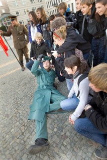 DEU Berlin A man disguised as a GDR soldier during a group photo in front of the Brandenburg Gate.