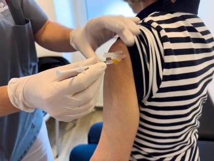 Patient woman receives injection in upper arm for vaccination against contagious disease flu flu