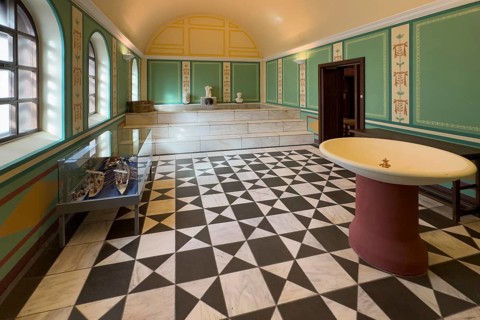Reconstructed Roman ancient caldarium hot bath heating room with hot water pool in the background