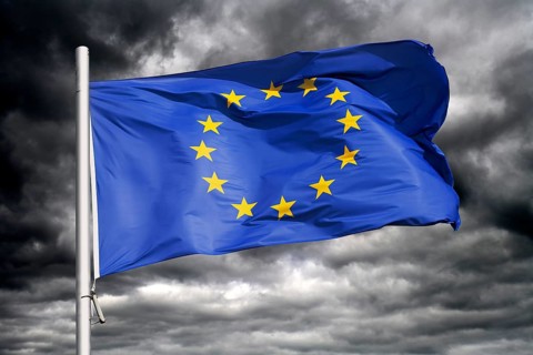 European Union flag waving against dark sky, photo montage