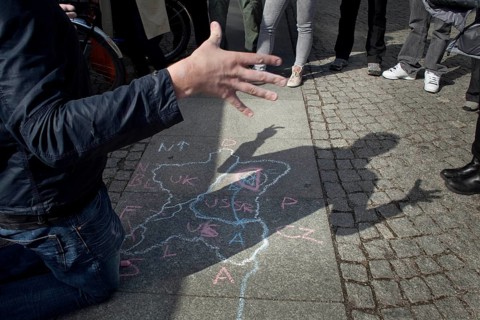 DEU Berlin A tourist guide explains the division of Germany with a circle drawing at Checkpoint