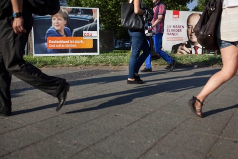 DEU Germany Germany Berlin Pedestrians pass the election posters of Angela Merkel CDU and Peer