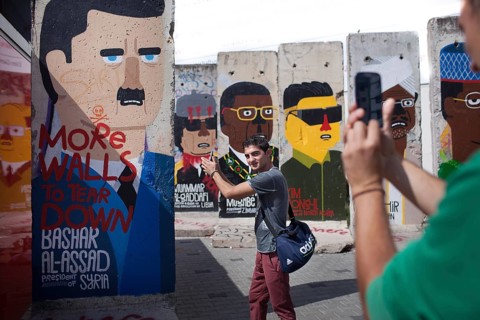 DEU Germany Germany Berlin A tourist has himself photographed shooting in front of Syrian dictator