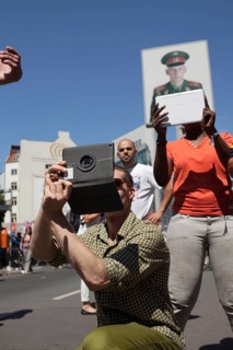 DEU Germany Germany Berlin Tourists take pictures with tablets at Checkpoint Charlie
