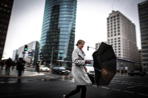 DEU Germany Germany Berlin Woman fighting against the wind at Potsdamer Platz