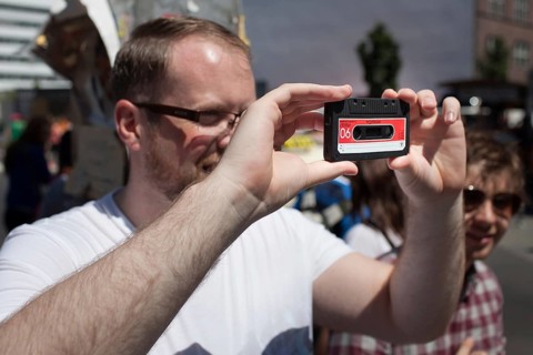 DEU Germany Germany Berlin tourist takes pictures with dummy cassette tape at Checkpoint Charlie