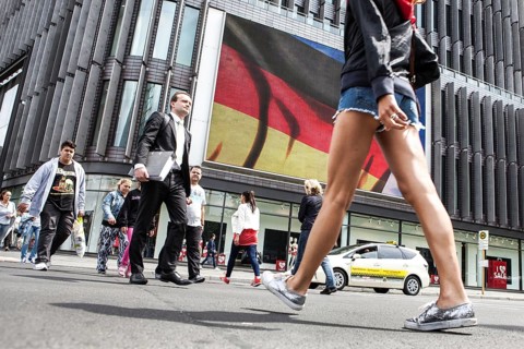 DEU Germany Germany Berlin Passers-by in front of a projection screen on Kurfürstendamm, on which a