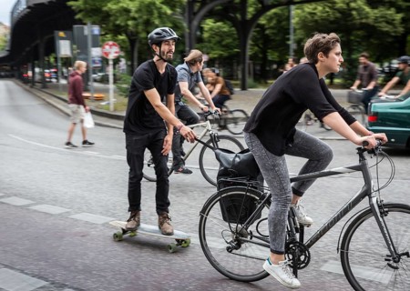 DEU Germany Germany Berlin female cyclist pulls skateboarders on Skalitzer Straße in Kreuzberg