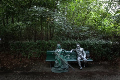 DEU Germany Germany Berlin Two performers take a break on a bench between the Reichstag and the