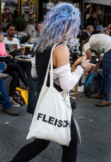 DEU Germany Germany Berlin Woman with blue-dyed hair wears a cloth bag with the inscription Flesh