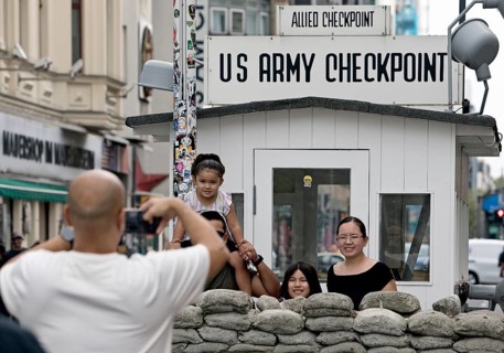 Tourists take a souvenir photo at Checkpoint Charlie, Berlin, Germany
