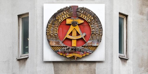 Old building of the Wall Museum — Museum Haus am Checkpoint Charlie with old GDR coat of arms,