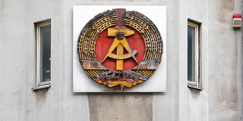 Old building of the Wall Museum — Museum Haus am Checkpoint Charlie with old GDR coat of arms,