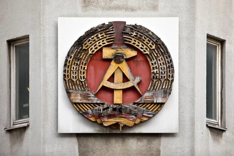 Old building of the Wall Museum — Museum Haus am Checkpoint Charlie with old GDR coat of arms,