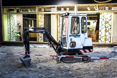 DEU Germany Germany Berlin A small excavator stands in front of an interior decoration shop