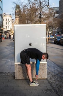 DEU Germany Germany Berlin A jogger does gymnastics in front of an Apple shop display case on