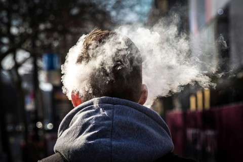 DEU Germany Germany Berlin Smoke from an e-cigarette envelops a man's head on Kudamm