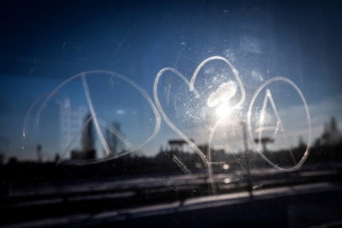 DEU Germany Germany Berlin The symbols of peace, love and anarchy are carved on the window of an
