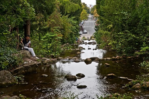 Artificial waterfall in Victoria Park with Großbeerenstraße in the background, Berlin-Kreuzberg,