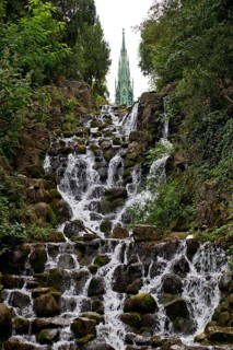 Artificial waterfall in Victoria Park, with the national monument on Kreuzberg in the background,