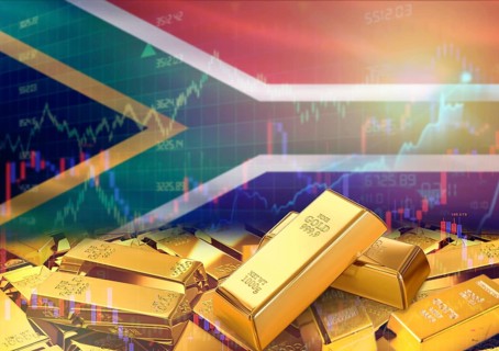 Gold bars on South Africa flag in background. Gold bars stacked on South African flag. Concept of