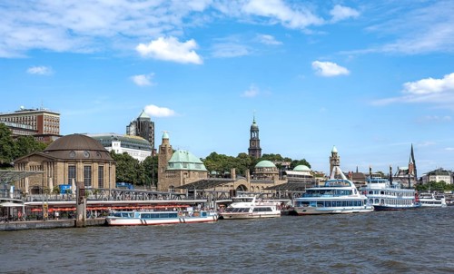 Elbe and boats at the St. Pauli piers, historic building with a level tower, in the back church