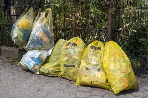 Yellow bags for plastic waste are lying on the side of the road, waste separation, waste disposal,