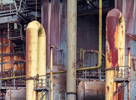 Weathered rusty industrial scenery with old corroded steel girders and metal tubes