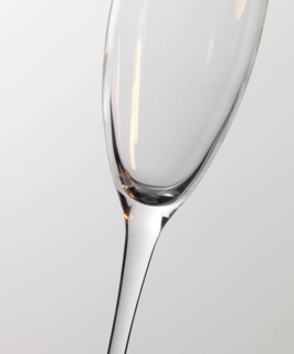 Studio photography of a champagne glass detail with warm light reflections