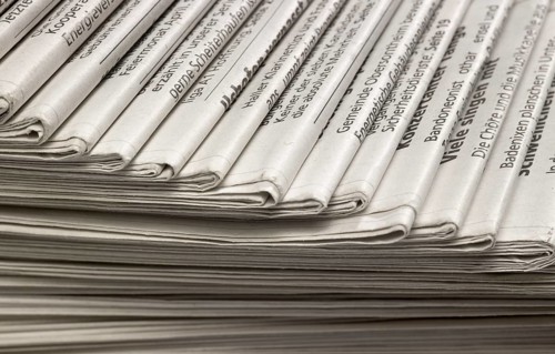 Full frame background with lots of stacked newspapers