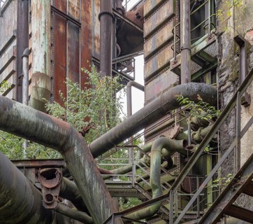 Weathered rundown industrial scenery with old corroded steel girders and metal tubes