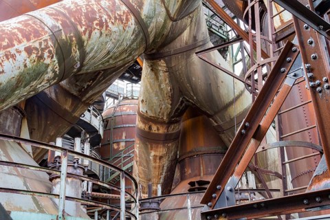 Weathered rusty industrial scenery with old corroded steel girders and metal tubes