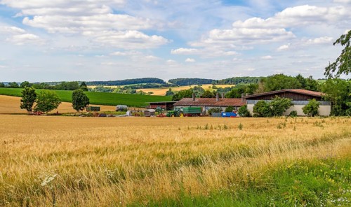 Idyllic agricultural scenery including some equipment at summer time in Southern Germany