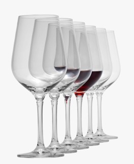 Some wine glasses standing consecutive in a row in white back, one partly filled with red wine