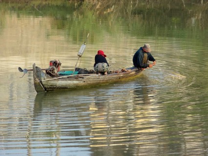 Riparian scenery with small boat at a river in Cambodia