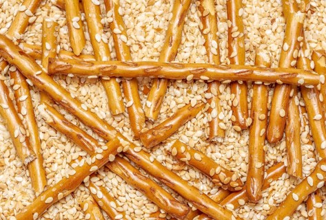Full frame closeup of some baked sesame sticks in sesame back