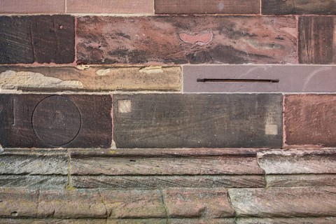 Historic engravings on a stone wall at the Freiburg Minster in Freiburg im Breisgau, a city in