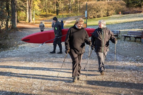 DEU Germany Germany Berlin A stand-up paddler behind two Nordic walkers at Krumme Lanke