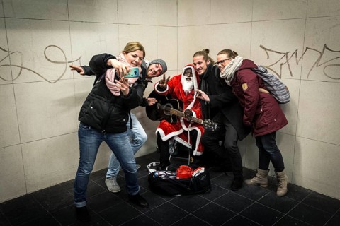 DEU Germany Germany Berlin A dark-skinned singer dressed as Father Christmas plays the guitar in
