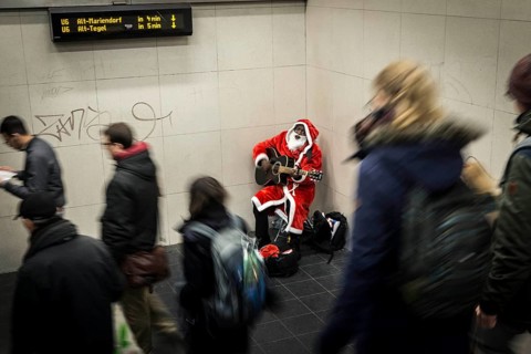 DEU Germany Germany Berlin A dark-skinned singer dressed as Father Christmas plays the guitar in
