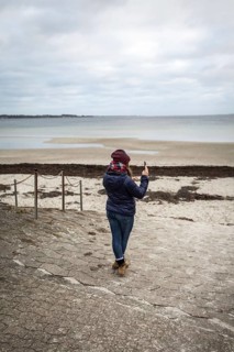 DEU Germany Germany Flensburg A woman takes a photo with her mobile phone on the beach at Holnis
