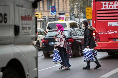 DEU Germany Germany Berlin Two woman try to cross the main street in Schöneberg with shopping bags